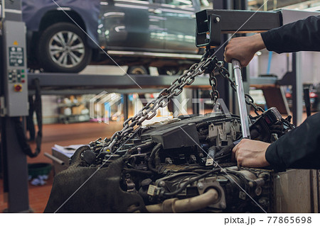 Auto engine repair on auto-parsing for sale, timing, tensioners, industrial roller chain, technology with selective focus. Team work in the office, business. Auto engine repair on auto-parsing for sale, timing, tensioners, industrial roller chain, technology with selective focus. Team work in the office, business. 77865698