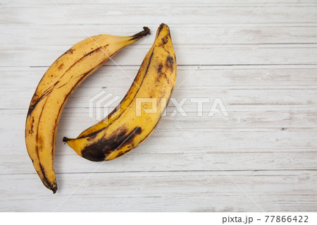 Plantain or Green Banana (Musa x paradisiaca) on white wooden background Plantain or Green Banana (Musa x paradisiaca) on white wooden background 77866422