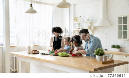 Young multiracial family with kids cook in kitchen 77866612