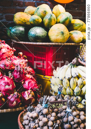 Exotic and tropical fruits on the market of Asia, Thailand, Vietnam. Mini bananas, longan, pitaya Dragon Fruit, papaya. 77866860