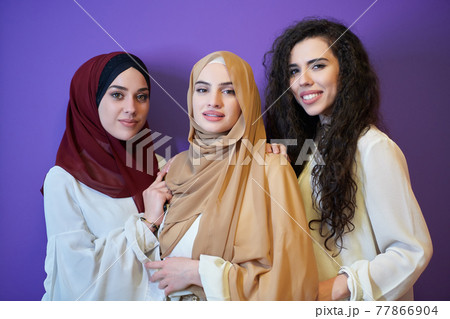 Young muslim women posing on purple background Young muslim women posing on purple background 77866904