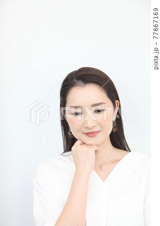 頬杖をつく下目線の若い女性 77867169