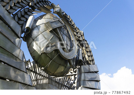 Moscow, Russia - November 7, 2018: Monument of USSR national soviet emblem made from metal on blue sky. Brutal USSR concept. Moscow, Russia - November 7, 2018: Monument of USSR national soviet emblem made from metal on blue sky. Brutal USSR concept. 77867492