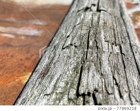 Surface texture of natural gray wood in the form of a board and rusty old oxidized corrosive metal iron close-up view. The background Surface texture of natural gray wood in the form of a board and rusty old oxidized corrosive metal iron close-up view. The background 77869218