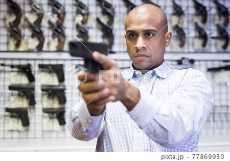 Portrait of customer which is choosing pistol in army market Portrait of customer which is choosing pistol in army market 77869930