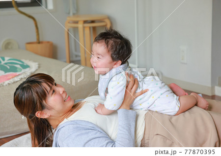 乳児をおなかの上に乗せてあやす母親2 77870395