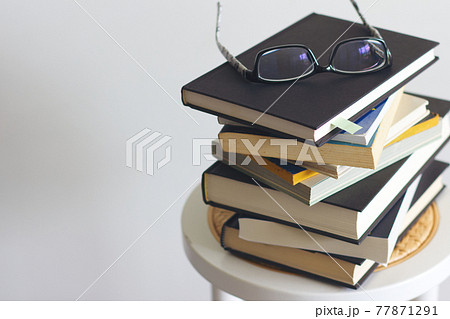 積まれた本とメガネ 77871291