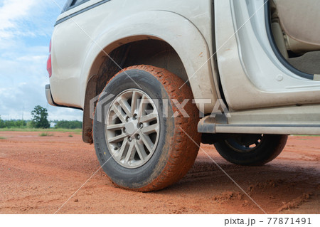 Muddy car tire wheel, red soil surface dirt road. Adventure in journey. Mud. Muddy car tire wheel, red soil surface dirt road. Adventure in journey. Mud. 77871491