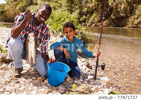 Man and boy with bucket of catch Man and boy with bucket of catch 77871727