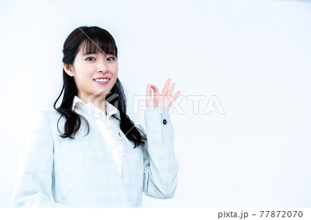 スーツでOKポーズをする若い女性 77872070