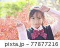 紅葉バックで案内する学生　制服 77877216