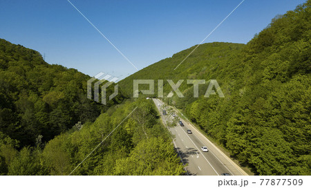 Mountain winding zig zag road. Top aerial view: cars driving on road from above. 77877509