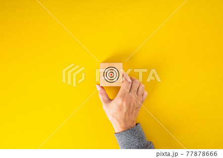 businessman hand put square block with aim at concentric circles of marketing target. 77878666