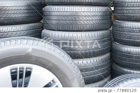 Several car tires are lined up in a tire shop. 77880120