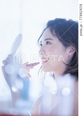 ビューティー　メイクシーン　リップを塗る若い女性 77882658