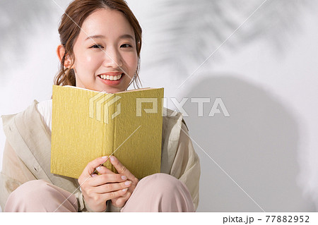 屋外で読書をする若い女性 77882952