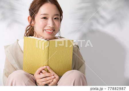 屋外で読書をする若い女性 77882987