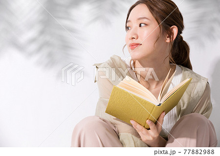 屋外で読書をする若い女性 77882988