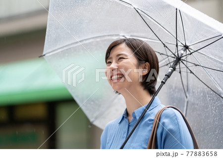 若い女性　雨　傘　梅雨 77883658