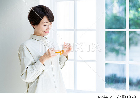 窓際で紅茶を飲む女性 77883828
