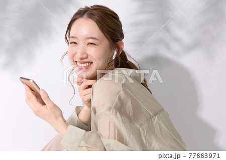 スマホでお気に入りの音楽を聴く若い女性 77883971