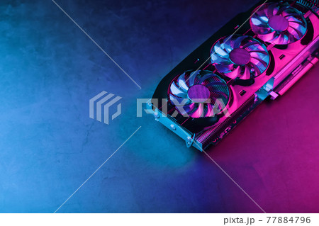 A graphics card with a row of fans with a cyanotic purple backlight in a futuristic design. 77884796