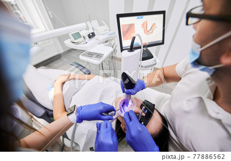 Doctor scanning patient mouth with modern intraoral scanner. Doctor scanning patient mouth with modern intraoral scanner. 77886562