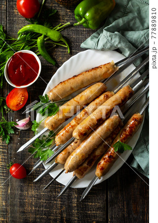 Summer Barbecue menu. Grilled sausages on rustic wooden table. Top view flat lay background. 77889810