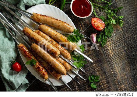 Summer Barbecue menu. Grilled sausages on rustic wooden table. Top view flat lay background. Copy space. 77889811