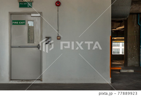 Fire exit door for emergency case with alarm for safety protection of the car parking building near the Condominium building. 77889923