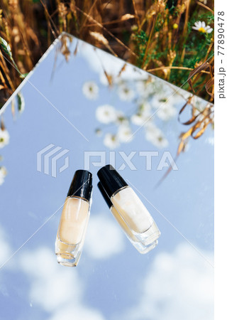 White tubes of cream in a field on a mirror surface 77890478