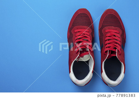 Pair of stylish red sneakers on color background, space for text. 77891383