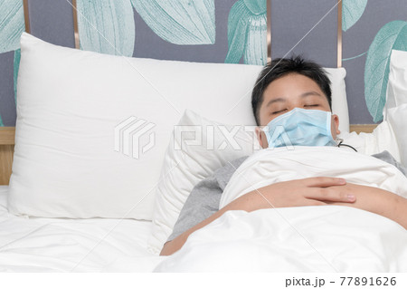 sick boy wear mask and sleep on bed, protect covid-19 77891626