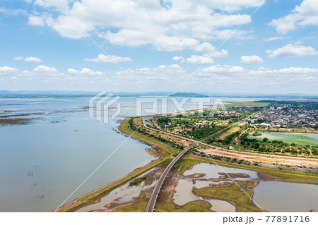 Aerial view of the railway bridge and community near Pasak Chonlasit Dam 77891716