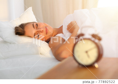 Beautiful blonde girl sleeping sweetly in sunny bedroom on a white bed. Holyday comfort and Rest concepts Beautiful blonde girl sleeping sweetly in sunny bedroom on a white bed. Holyday comfort and Rest concepts 77892522