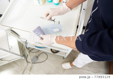 Top view of doctor beautician holding a syringe with beauty product for making face injection 77893129
