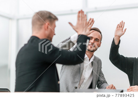 confident business colleagues giving each other a high five 77893425
