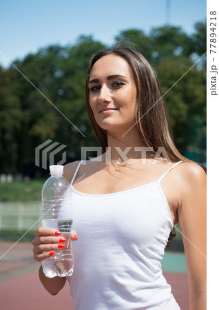 Sexy woman with plastic bottle on stadium. Woman 77894218
