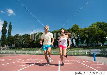 Couple running on arena track 77894219