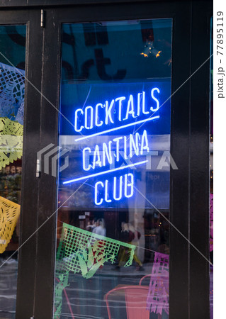 店の窓に飾られた青いネオンサイン　ロンドン東のショーディッジにて 77895119