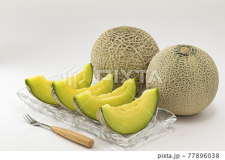 白バックに並べたメロンとガラス皿に置いたカットメロン 77896038
