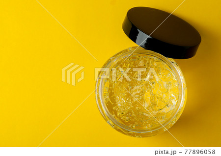 Jar of styling gel on yellow background Jar of styling gel on yellow background 77896058