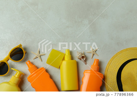 Summer concept with sunscreens on textured background Summer concept with sunscreens on textured background 77896366