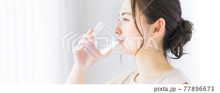 ミネラルウォーターを飲む若い女性 77896673