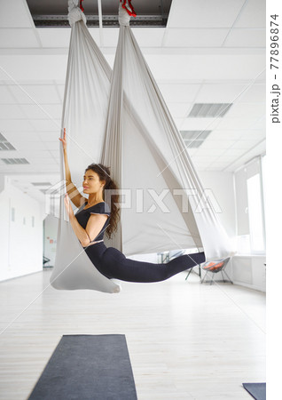 Aerial yoga, slim woman poses on hammock Aerial yoga, slim woman poses on hammock 77896874