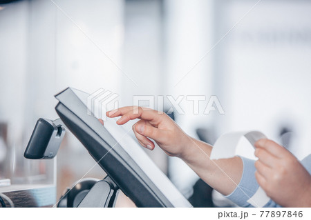 Concept of small business or sevice, woman or saleswoman in apron at counter with a cashbox working at clothes shop, touchscreen POS 77897846