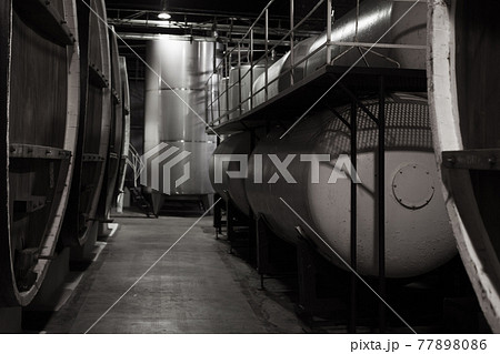 Dark wooden barrels and steel tanks 77898086