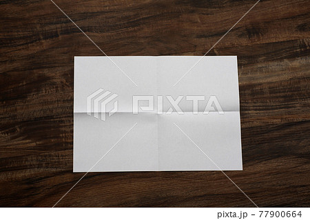 四つ折りにして開いた白い紙 77900664