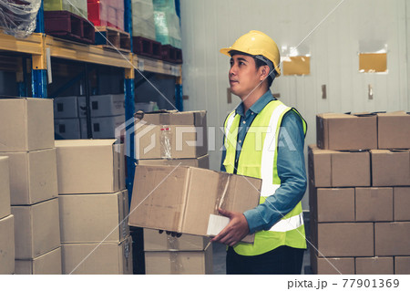 Asian warehouse worker checking packages in storehouse Asian warehouse worker checking packages in storehouse 77901369