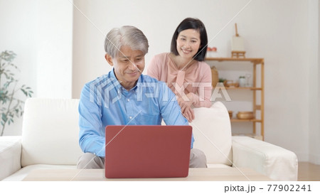 リビングでパソコンを使うミドル夫婦 77902241